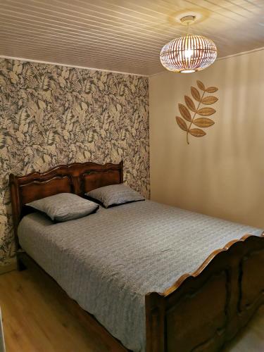 une chambre avec un lit et un lustre dans l'établissement Gîte 2 chambres avec piscine, à Sernhac