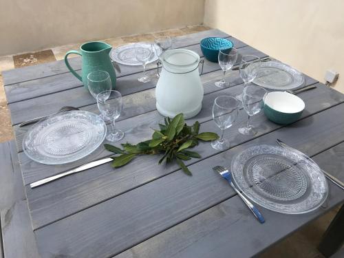 a table with wine glasses and plates on it at Les Mazets et Spa D'Uzes in Arpaillargues-et-Aureillac