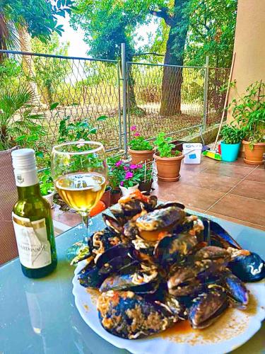 a plate of oysters and a glass of wine on a table at Dream apartment Herceg Novi in Herceg-Novi