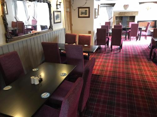 a restaurant with tables and chairs and a red carpet at The Miners Arms in Eyam