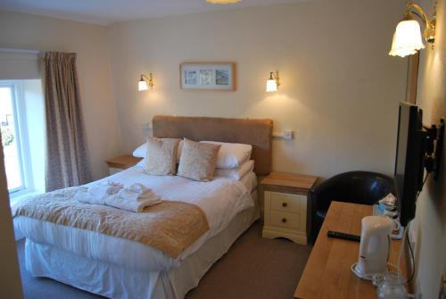 a hotel room with a bed with towels on it at The Miners Arms in Eyam