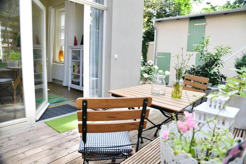 een patio met een houten tafel en stoelen op een veranda bij JETHON Studio-Appartement im Grünen in Bernburg