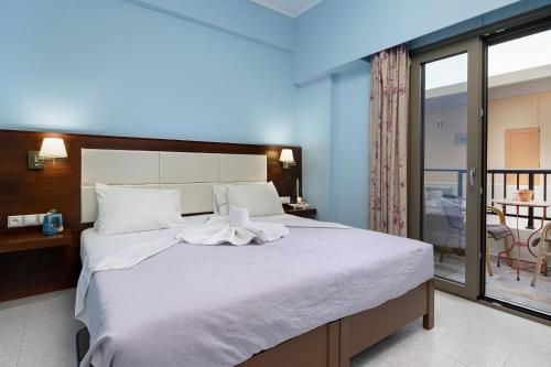 1 dormitorio con 1 cama grande y balcón en Avra en Agia Galini