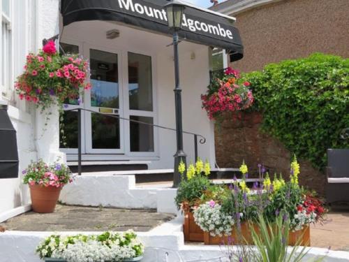 a store with flower pots in front of a building at Mount Edgcombe in Torquay