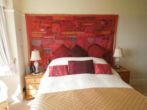 a bedroom with a large bed with a red wall at Mounthaven Guest House in Dartmouth