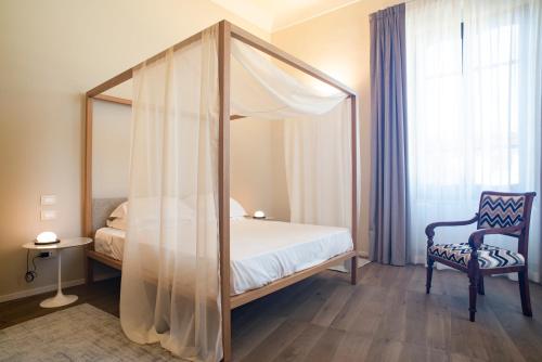 a bedroom with a canopy bed and a chair at Dimora de Matera Luxury Suites in Cosenza