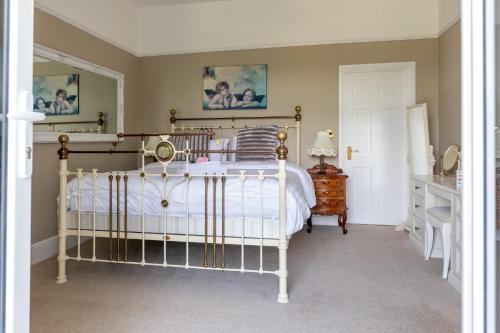a bedroom with a bed and a desk and a mirror at Plas Maenan in Conwy