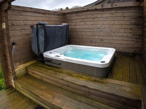 eine Whirlpool-Badewanne auf einer Holzterrasse in der Unterkunft New Forest Lodges in Cranborne