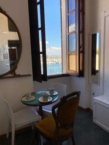 アルゲーロにあるPalazzo Bolascoのテーブルと椅子、窓が備わる客室です。