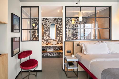 マルチェージネにあるHotel Gardenのベッドと赤い椅子が備わるホテルルームです。