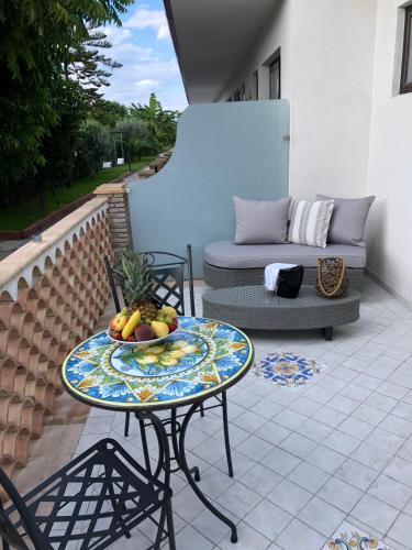 a table with a bowl of fruit on a patio at Paradise Sicily Rooms in Calatabiano
