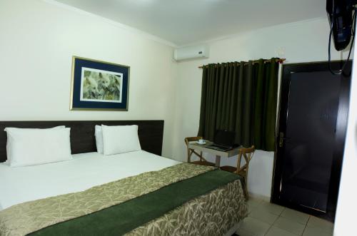 1 dormitorio con 1 cama y cortina verde en Vancouver Hotel- 500 Metros Rodovia Anhanguera, en Ribeirão Preto