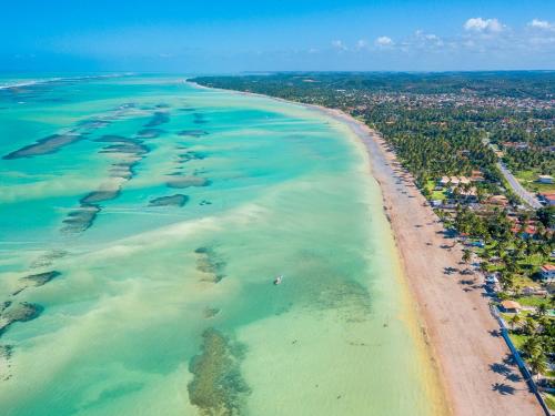 una vista aérea de la playa y del océano en Parque dos Coqueiros- Bangalos e Suites, en Maragogi