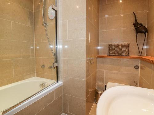a bathroom with a shower and a tub and a toilet at The Bolt Hole in Torpoint