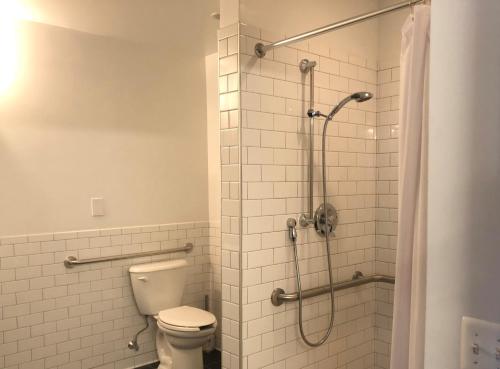 a bathroom with a toilet and a shower at The Local NY in Queens
