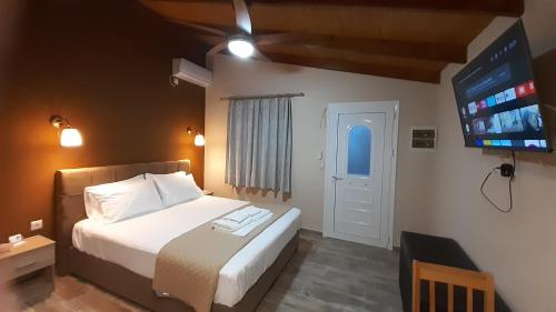 sypialnia z łóżkiem i telewizorem z płaskim ekranem w obiekcie Room near the Airport w mieście Pikérmion