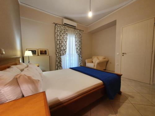 a bedroom with a bed and a chair and a window at Family Cozy Apartment in Heraklio