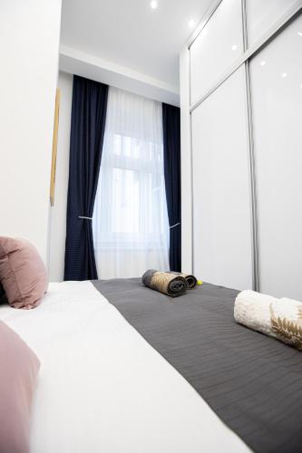 a bedroom with a white bed and a window at Theatre Square Apartments in Novi Sad