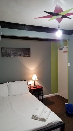 a bedroom with a white bed and a ceiling fan at City View Hotel Roman Road in London