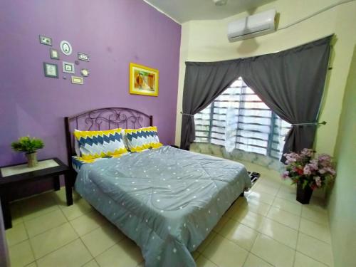 a bedroom with a bed and a purple wall at Umai homestay in Bandar  Pusat Jengka