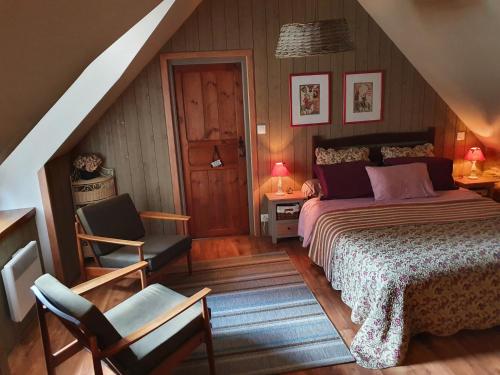 a bedroom with a bed and a chair in a attic at Le Triskelium in Landebaëron