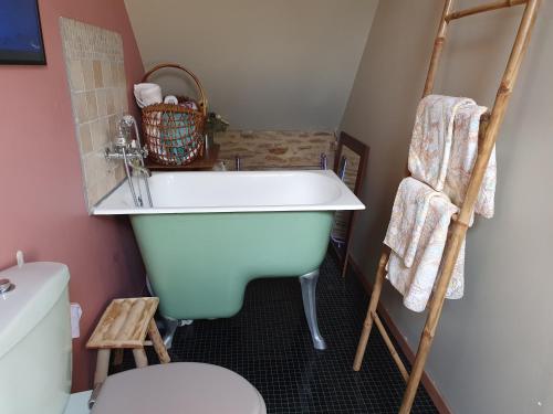 a bathroom with a white tub and a toilet at Le Triskelium in Landebaëron