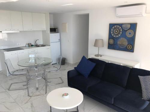een woonkamer met een bank en een tafel en een keuken bij Amazing View Apartment Estepona Puerto in Estepona