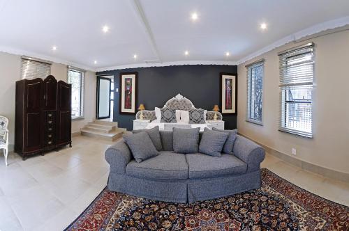 a living room with a couch and a bed at Le Grant Guesthhouse in Kroonstad