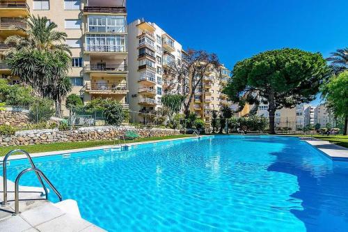 een groot blauw zwembad voor een gebouw bij Amazing View Apartment Estepona Puerto in Estepona