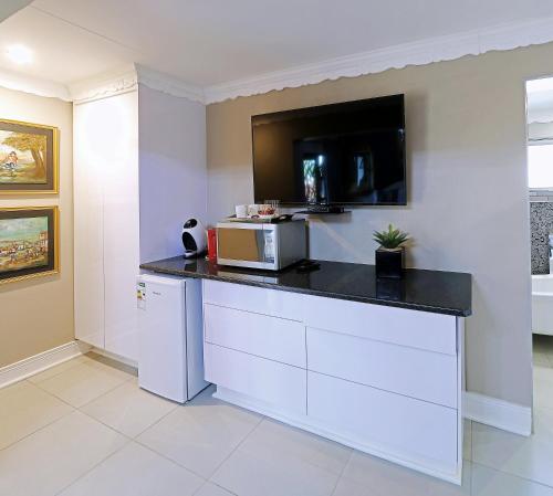 a kitchen with a counter with a microwave on it at Le Grant Guesthhouse in Kroonstad