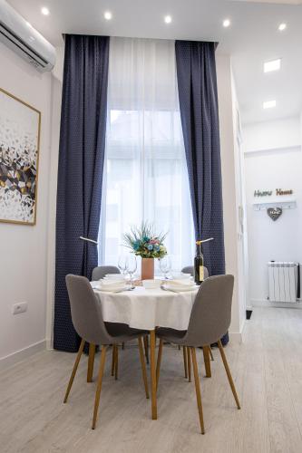 a dining room with a table and chairs and a window at Theatre Square Apartments in Novi Sad
