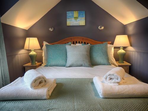una camera da letto con un letto con asciugamani sopra di The Lansdowne Cottage - Exclusive Welcome Hamper a Bourton on the Water