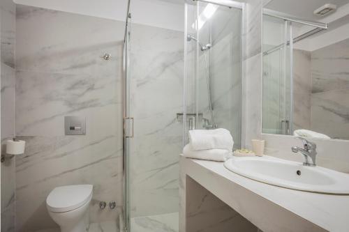 a bathroom with a toilet and a sink and a shower at Panorama Apartments Fiscardo in Fiskardho