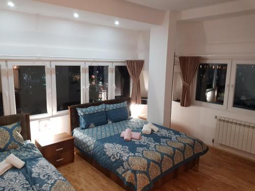 a bedroom with a bed with a blue comforter at Prishtina Newborn ABC room in Pristina