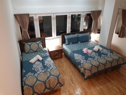 a bedroom with two beds and a window at Prishtina Newborn ABC room in Pristina