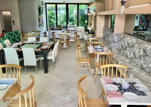 un ristorante con tavoli, sedie e un bancone di Arte Hotel a Santa Marta
