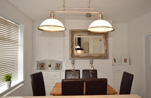 uma sala de jantar com uma mesa e um espelho em Havendene em Haworth