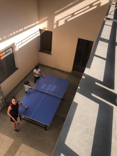 two people standing around a ping pong table in a room at Lara Hotel in Goris
