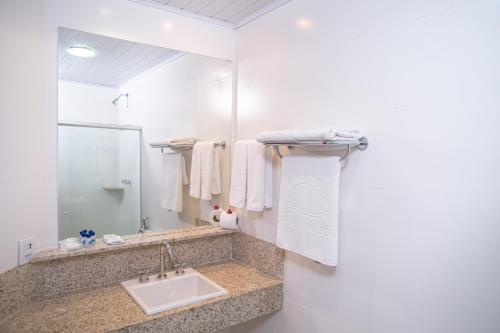 uma casa de banho com um lavatório e um espelho em Portobello Praia em Porto Seguro