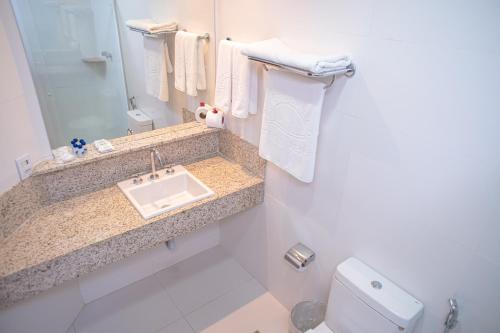 a bathroom with a sink and a toilet at Portobello Praia in Porto Seguro