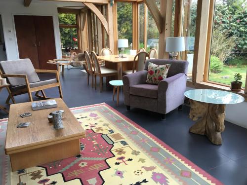 a living room with chairs and a table and a rug at Lower Crankan Farm in Penzance