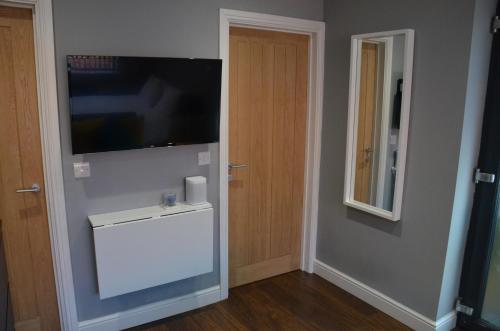 a room with a television on the wall and a door at The Annexe in Bracknell