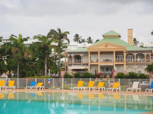un complexe avec des chaises et une piscine en face de lui dans l'établissement Holidays Guadeloupe -Paradise -Anse des Rochers, à Belle-Allée