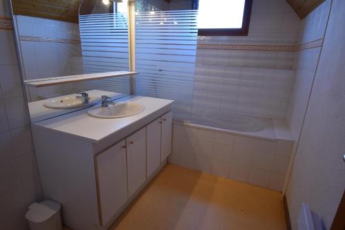 y baño con 2 lavabos, bañera y espejo. en VAUJANYLOCATIONS - Les Balcons de Vaujany, en Vaujany