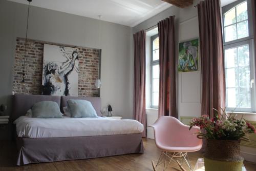 sypialnia z łóżkiem i ceglaną ścianą w obiekcie Maison Mathilde w mieście Valenciennes
