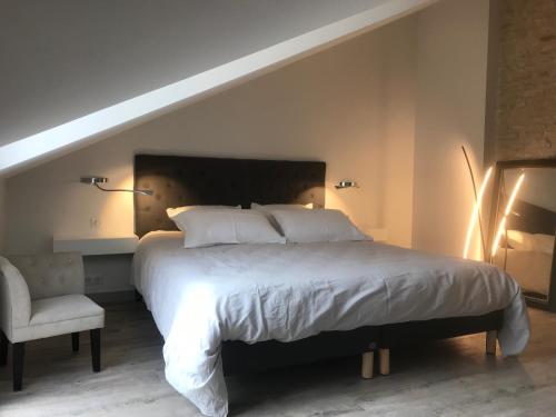 a bedroom with a large bed and a chair at Maison Loiseau - Maison Calme au Centre de Beaune in Beaune
