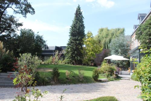 a garden with a green yard with a tree at Maison Mathilde in Valenciennes