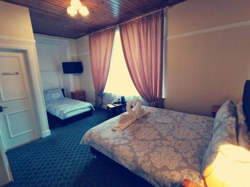 a hotel room with a bed with a teddy bear on it at Victoria Hotel in Blairgowrie