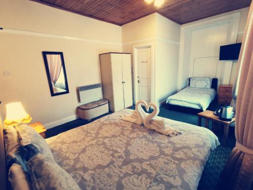 a bedroom with a bed with a stuffed animal on it at Victoria Hotel in Blairgowrie