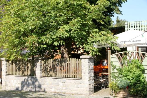 a fence with a tree in front of a house at Landgasthof Fischer Veri in Mitterfels
